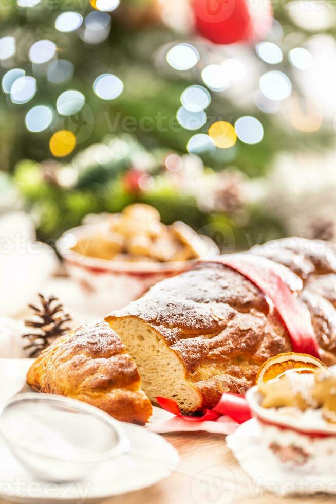 traditionnel tchèque Noël gâteau vanocka sur une de fête table dans de face de une Noël arbre photo