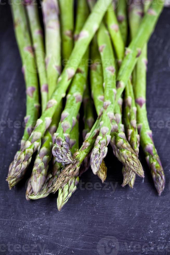 Gros plan d'asperges de jardin cru frais biologiques sur fond de tableau noir. légumes verts de printemps. photo