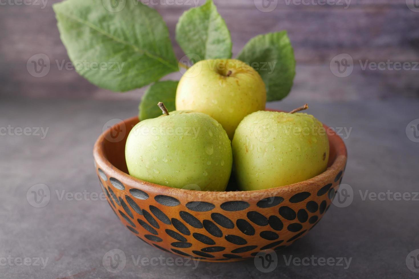 gros plan de pomme fraîche dans un bol sur une table en bois photo