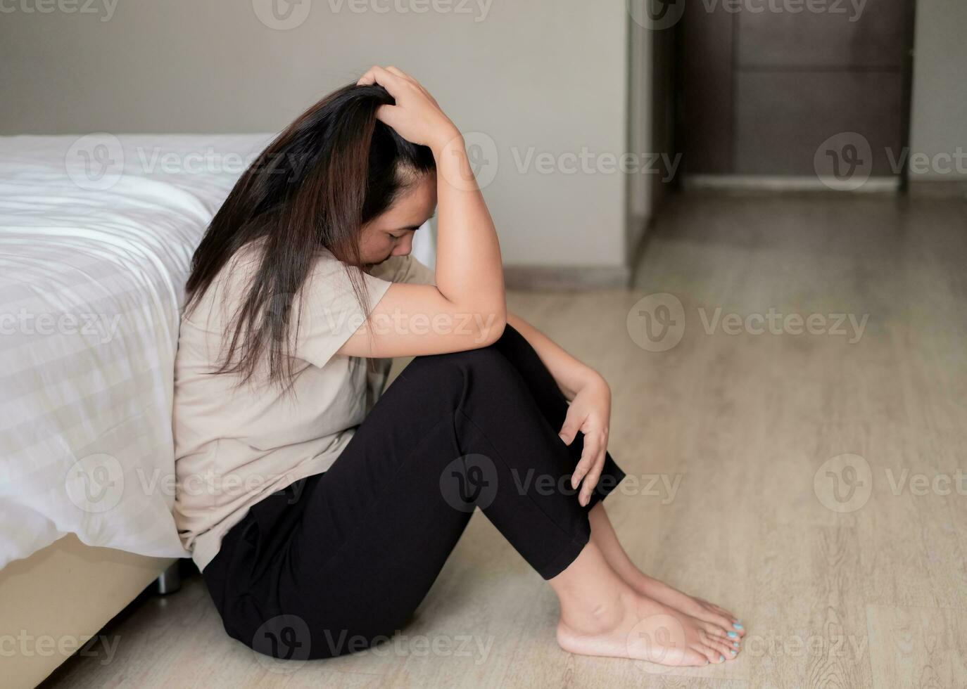 triste déprimé Asie femme Souffrance sur le blanc lit, elle est séance dans lit et émouvant sa front, sommeil désordre et stress concept photo