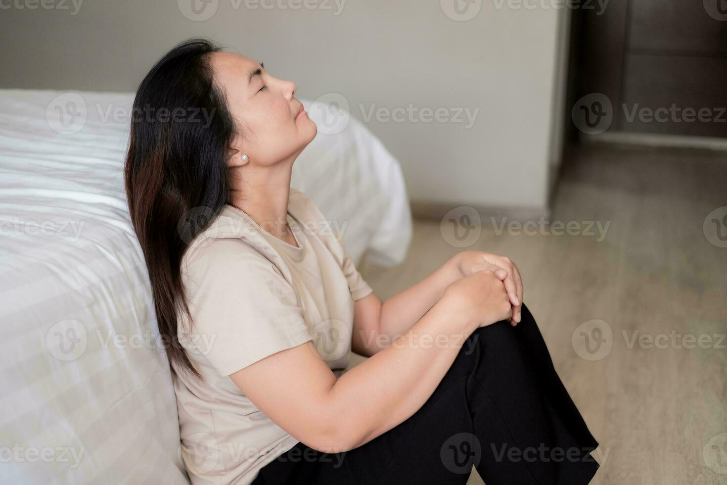 triste déprimé Asie femme Souffrance sur le blanc lit, elle est séance dans lit et émouvant sa front, sommeil désordre et stress concept photo