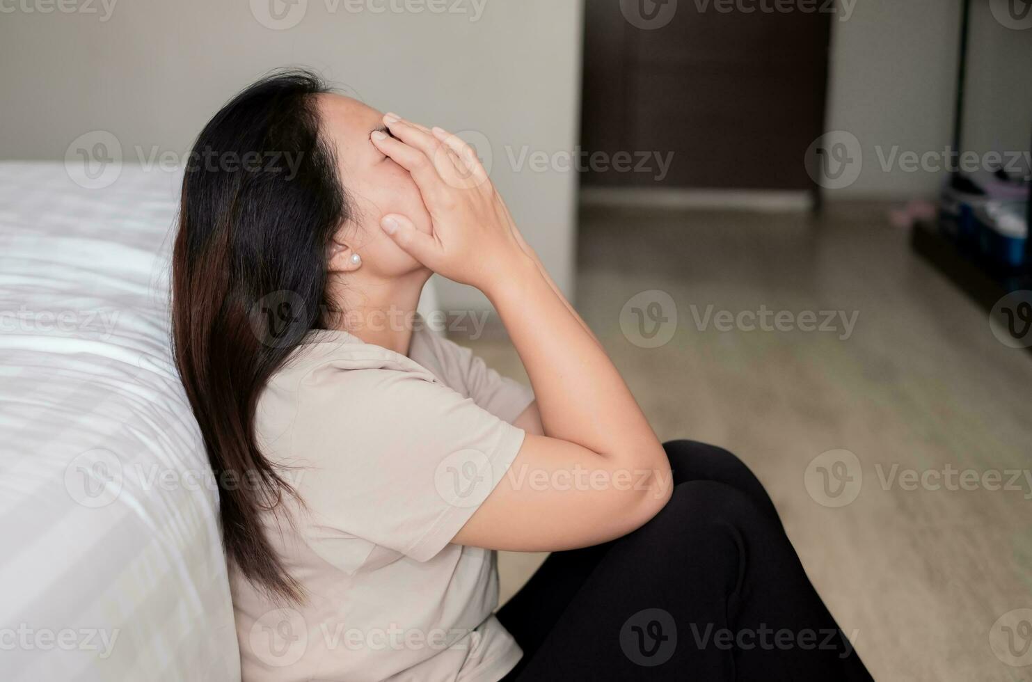 triste déprimé Asie femme Souffrance sur le blanc lit, elle est séance dans lit et émouvant sa front, sommeil désordre et stress concept photo