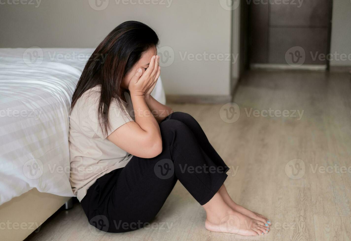 triste déprimé Asie femme Souffrance sur le blanc lit, elle est séance dans lit et émouvant sa front, sommeil désordre et stress concept photo