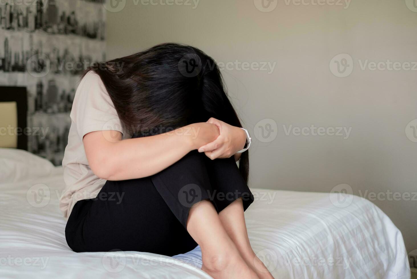 triste déprimé Asie femme Souffrance sur le blanc lit, elle est séance dans lit et émouvant sa front, sommeil désordre et stress concept photo