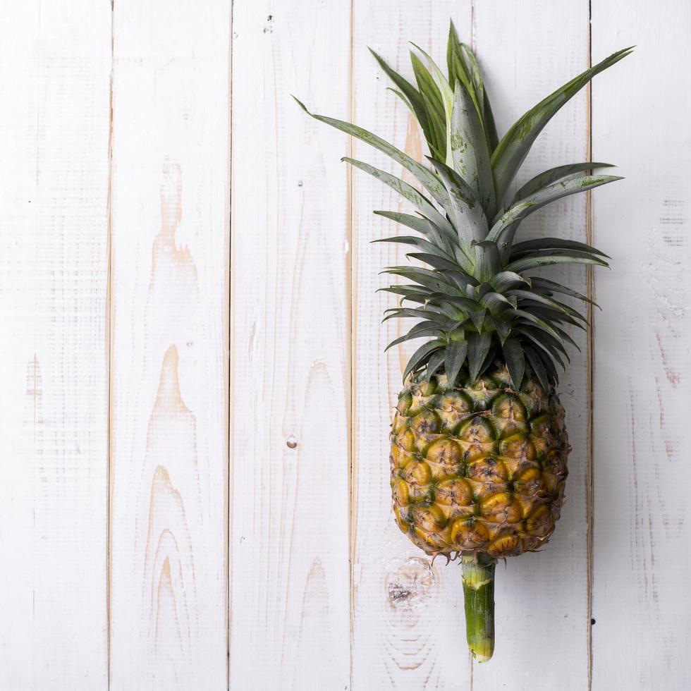 ananas sur fond de bois blanc photo