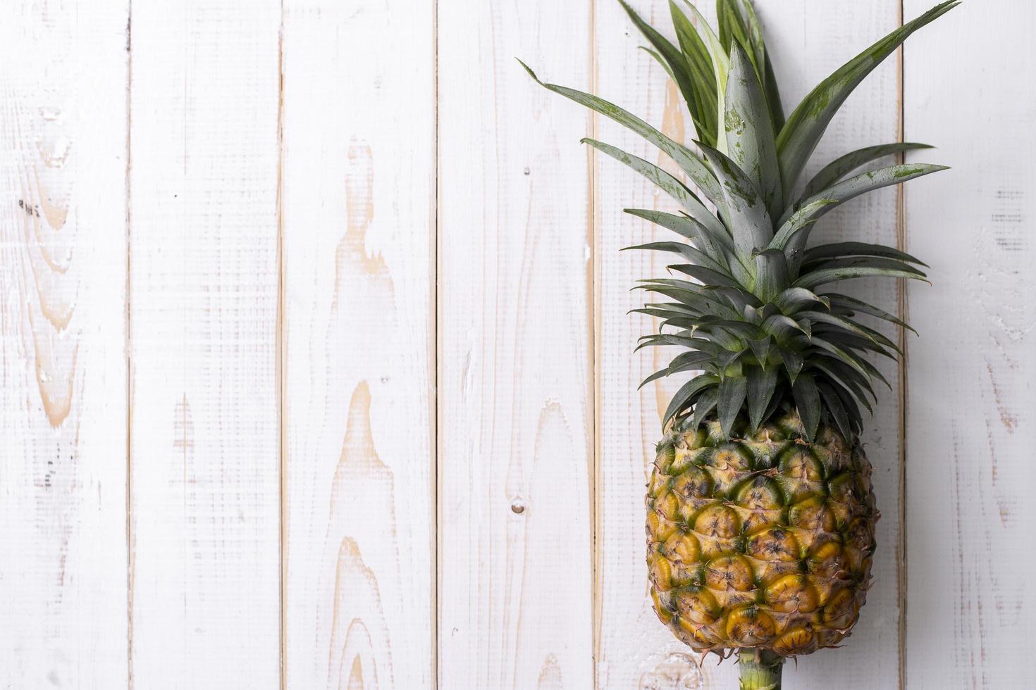 ananas sur fond de bois blanc photo