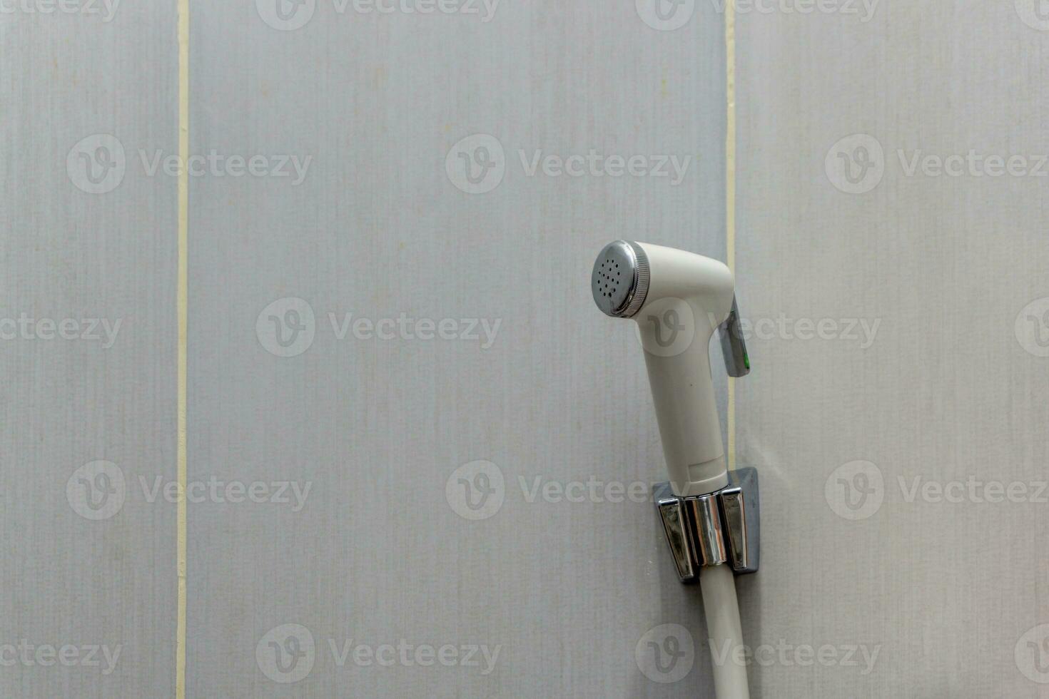 blanc bidet douche pendaison sur le blanc céramique mur. toilette douche pour la lessive externe génital. photo