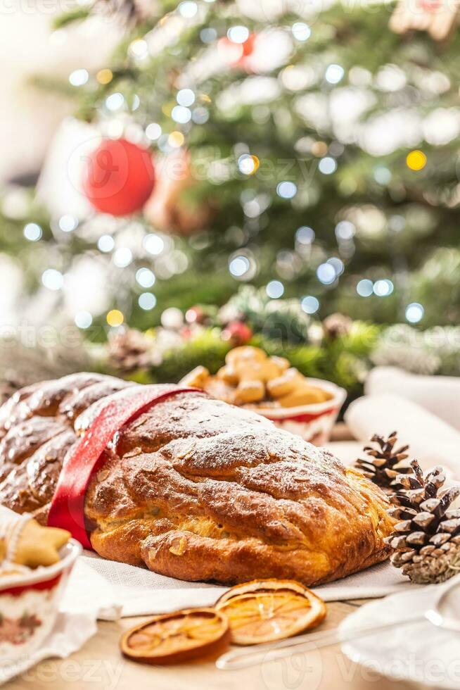 traditionnel tchèque Noël gâteau vanocka sur une de fête table dans de face de une Noël arbre photo