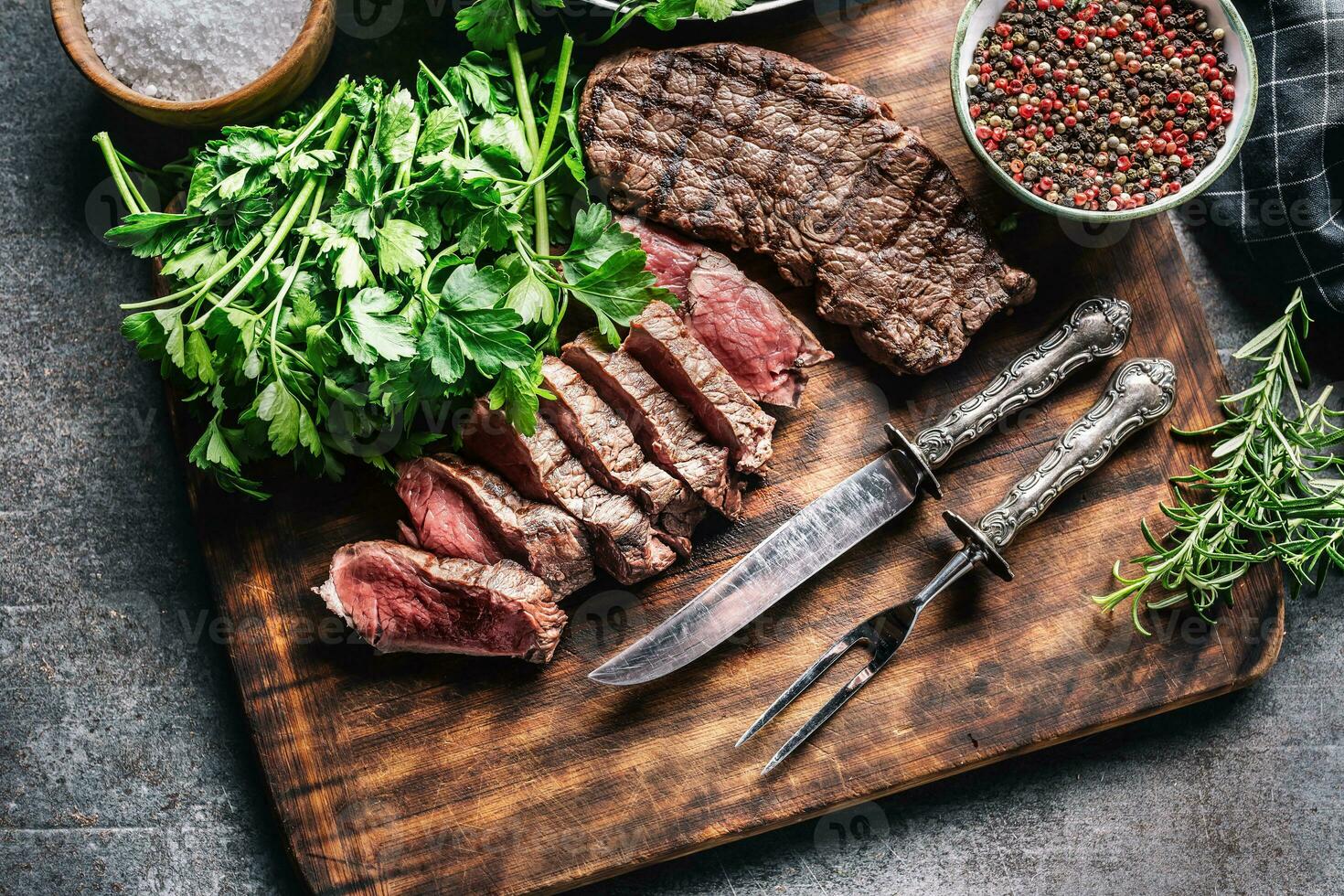 tranches de juteux grillé du boeuf steak avec fourchette et couteau sur une Boucher assiette photo