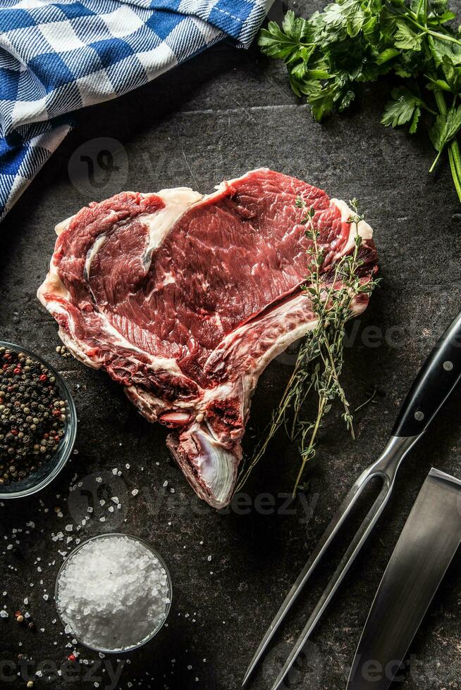 nervure œil steak avec OS sur Boucher planche avec herbes sel poivre fourchette et couteau photo