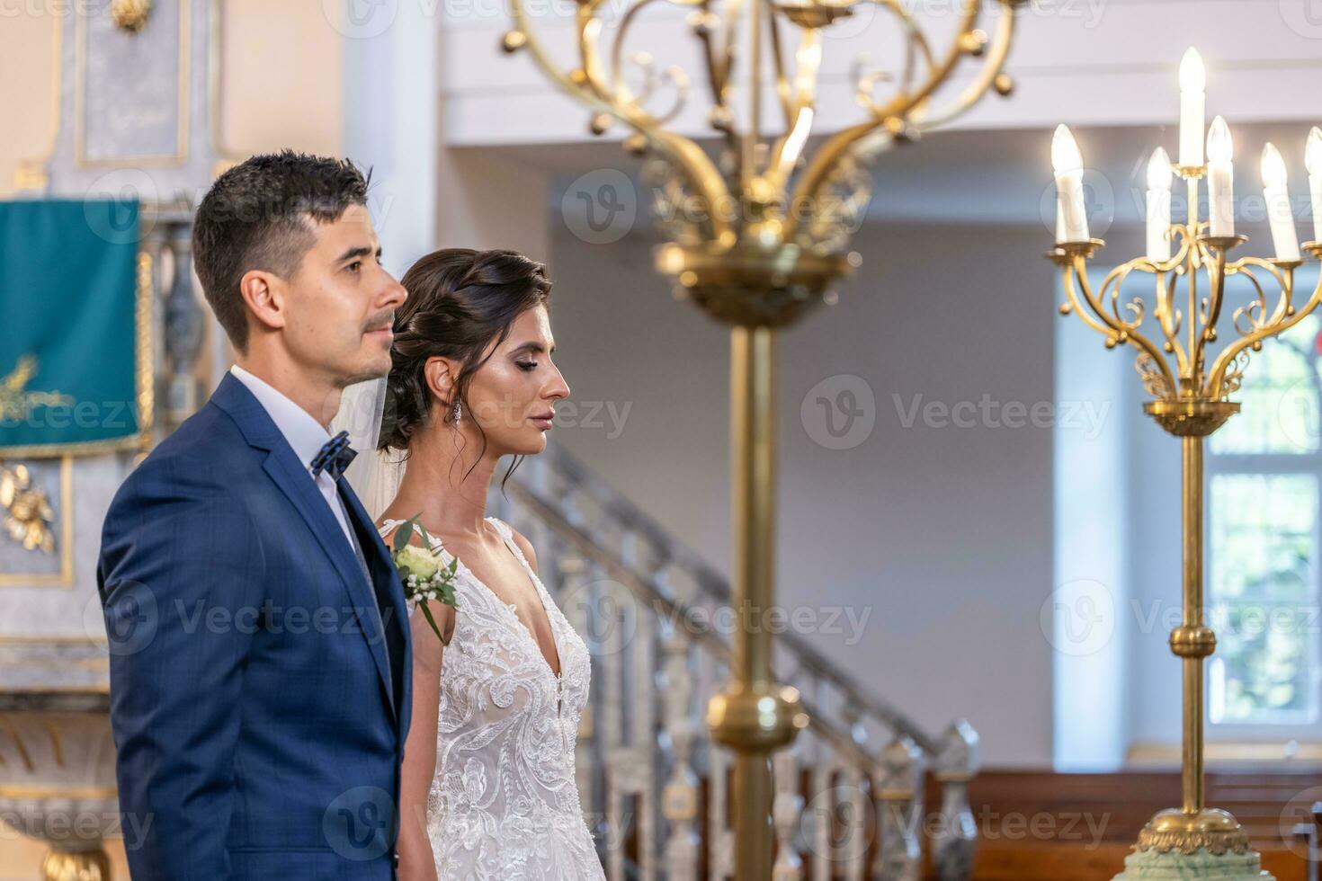 Jeune couple est avoir marié, permanent avec sérieux faciale expressions dans le église photo