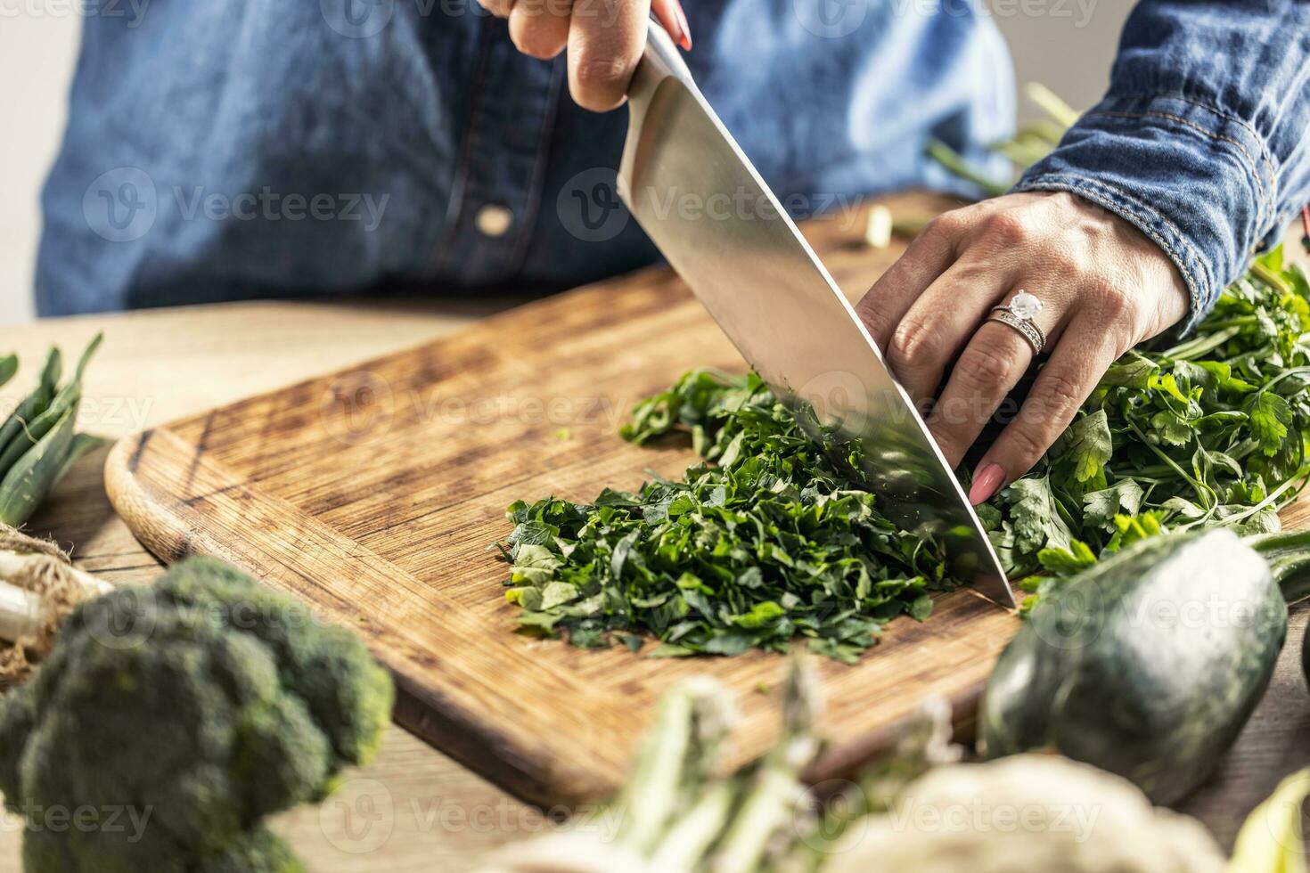 détail de femelle mains en portant une couteau et couper Frais persil légumes verts photo