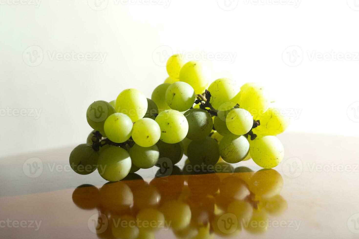 bouquet de vert les raisins sur en bois socle isolé lumière blanc Contexte. sélectif concentrer photo