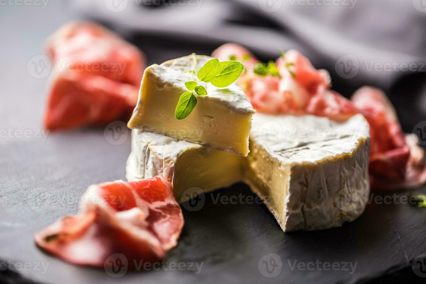 fromage camambert de prosciutto et Origan herbes. photo