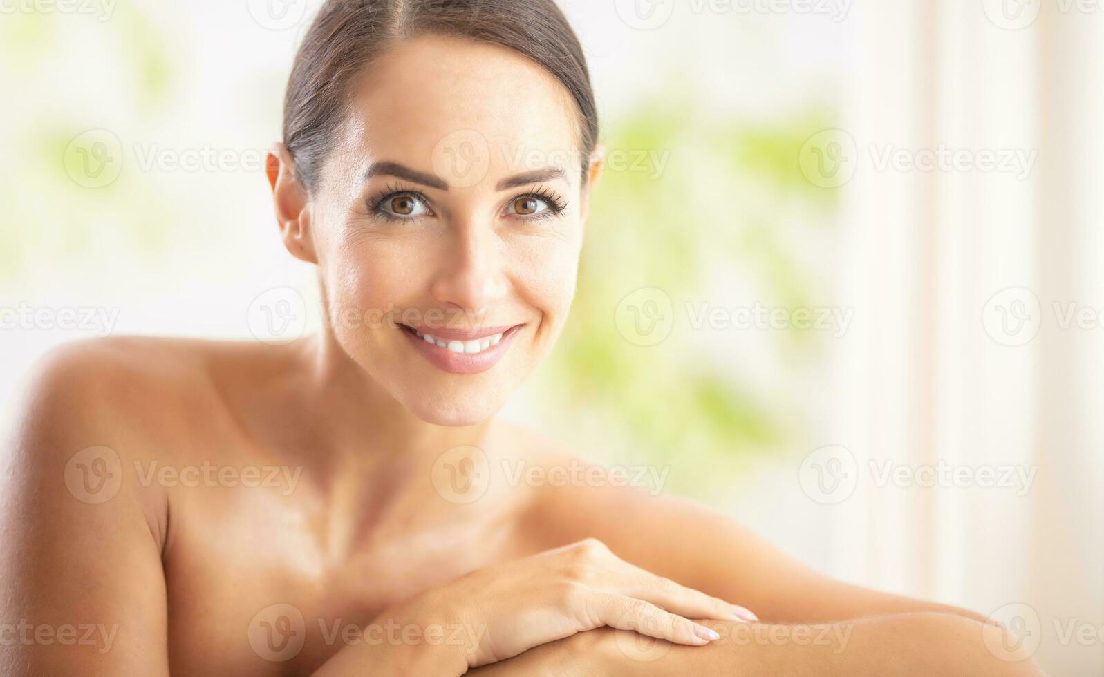 magnifique portrait de Jeune adulte femme avec nettoyer peau sans pour autant maquillage séance dans une beauté salon et à la recherche dans le caméra. spa soin de la peau bien-être et produits de beauté concept photo