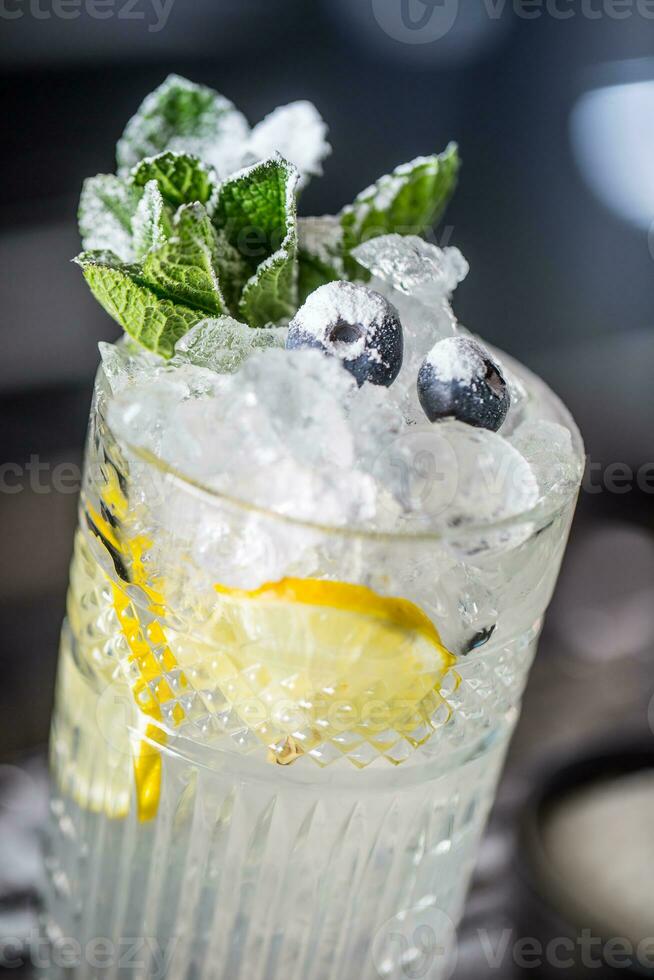 cocktail boisson avec myrtilles et menthe à comptoir dans nuit club ou restaurant photo