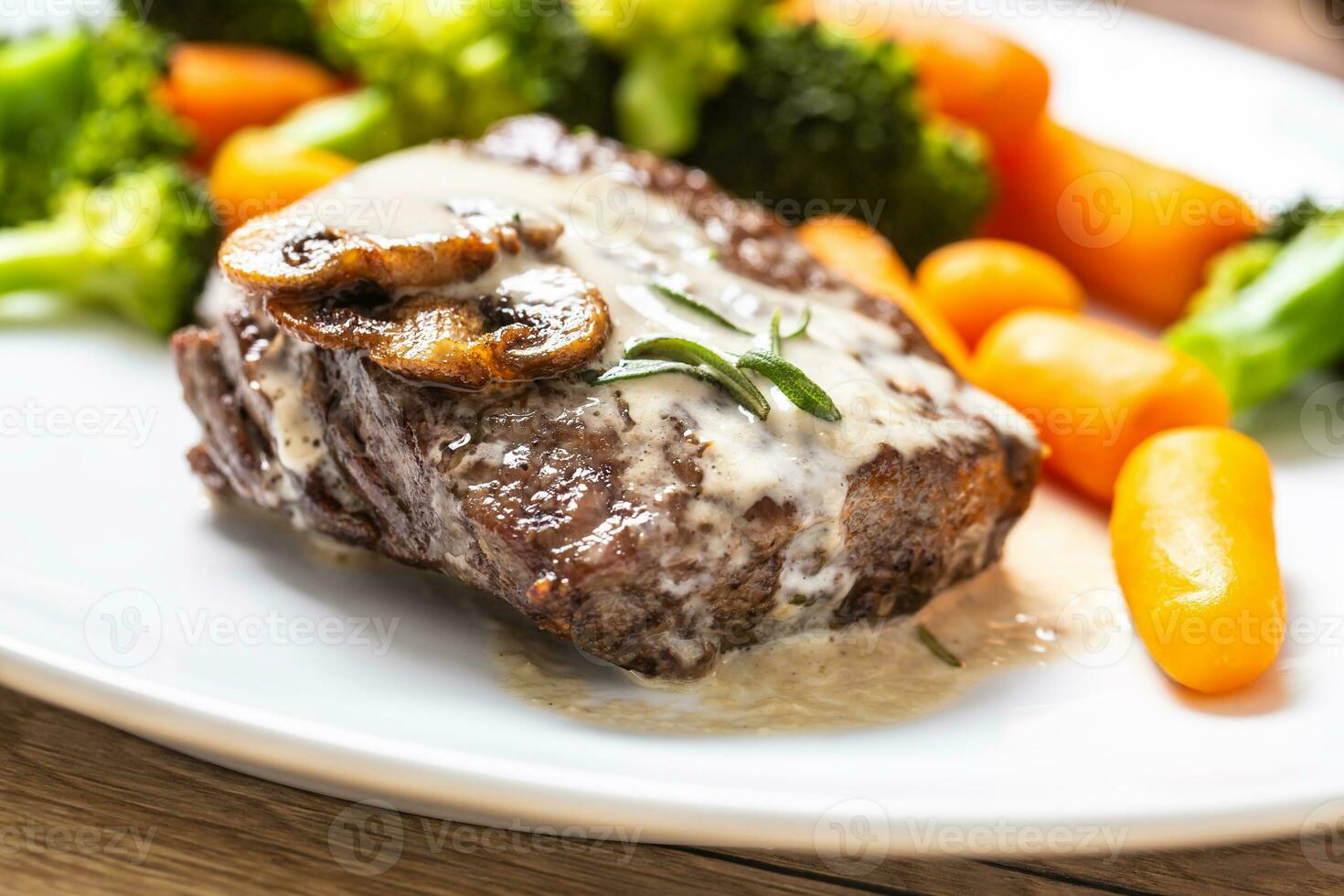 juteux du boeuf nervure œil steak avec champignon sauce et bébé légume photo