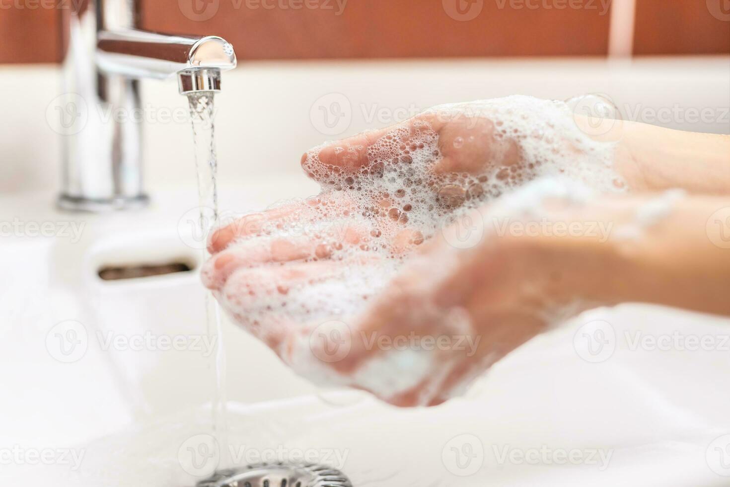 la lessive mains avec l'eau et liquide savon dans le salle de bains. hygiène antivirus concept photo