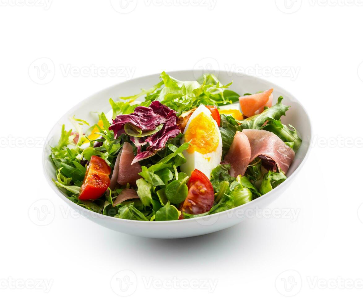 salade isolé sur blanche. une bol de Frais salade salade avec tomates des œufs prosciutto plus de blanc photo