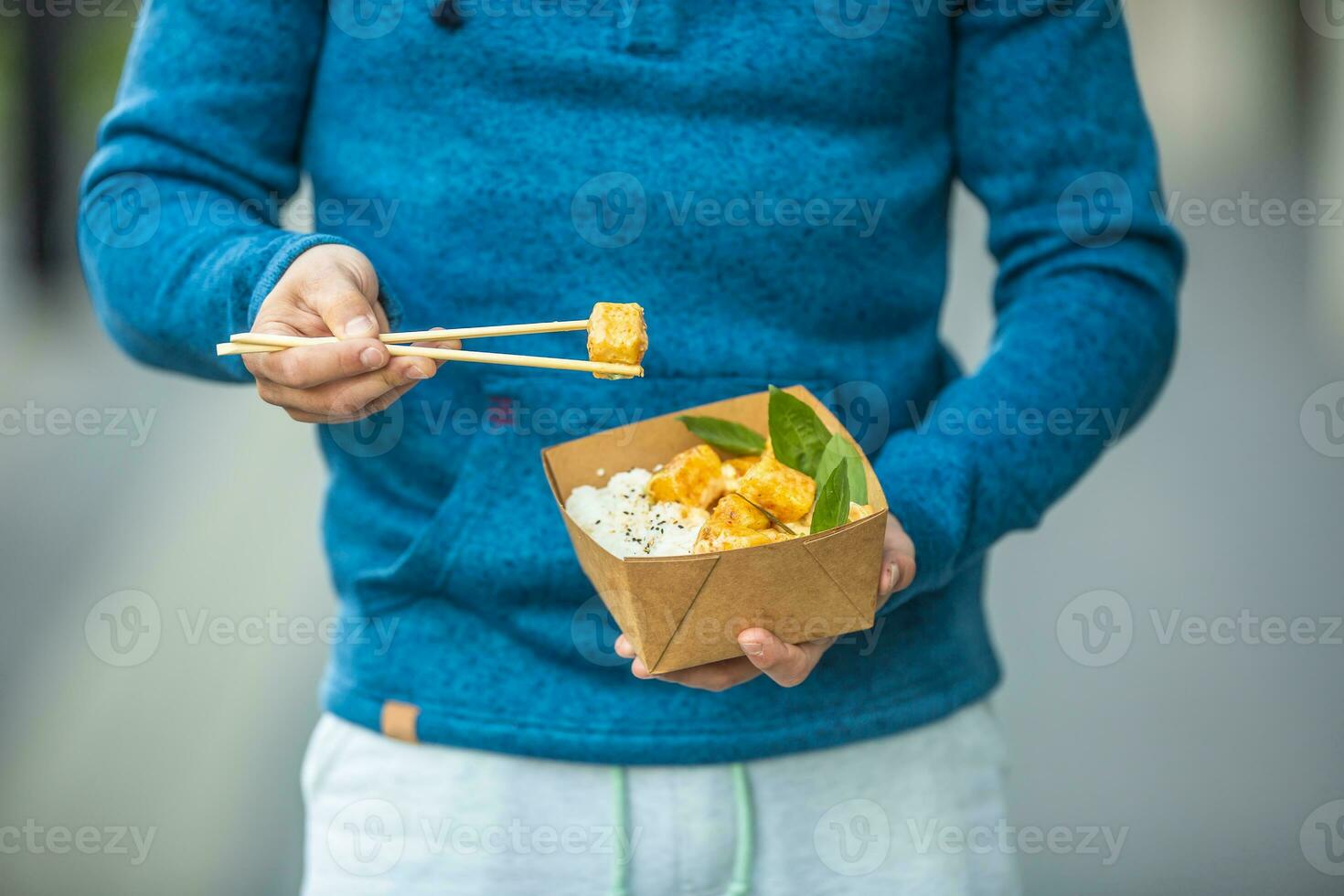 Jeune homme mains en portant le déjeuner dans une boîte de recyclé papier photo