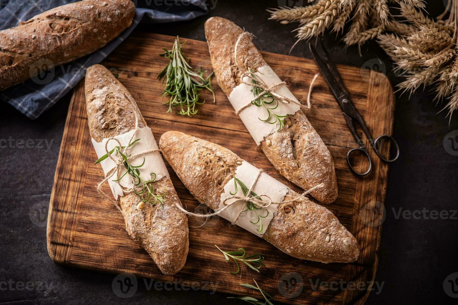 tope vue de fraîchement cuit Pâtisserie pain sur une ancien en bois planche avec foncé Contexte photo