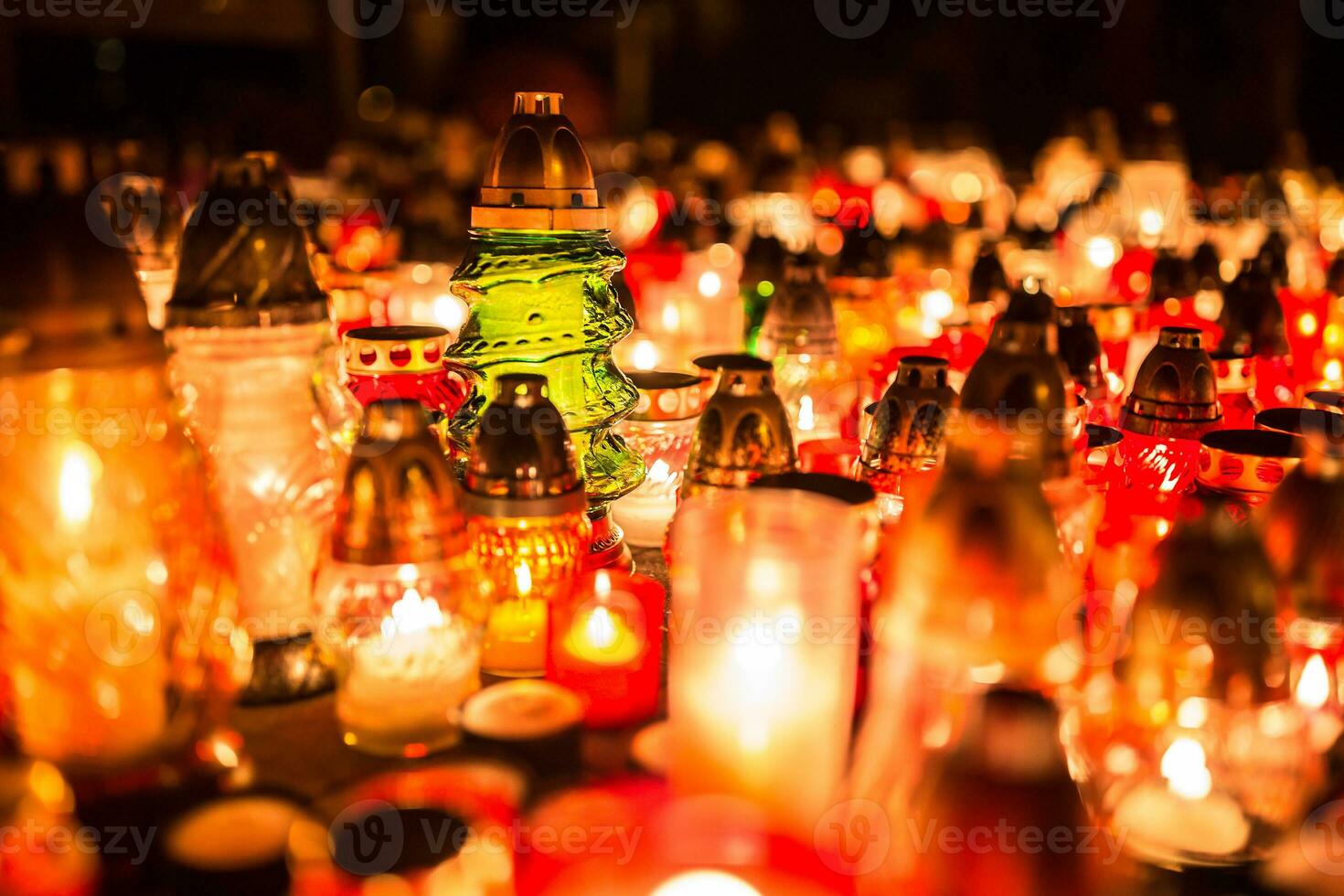 beaucoup brûlant bougies dans le cimetière à nuit sur le occasion âmes de le décédé photo