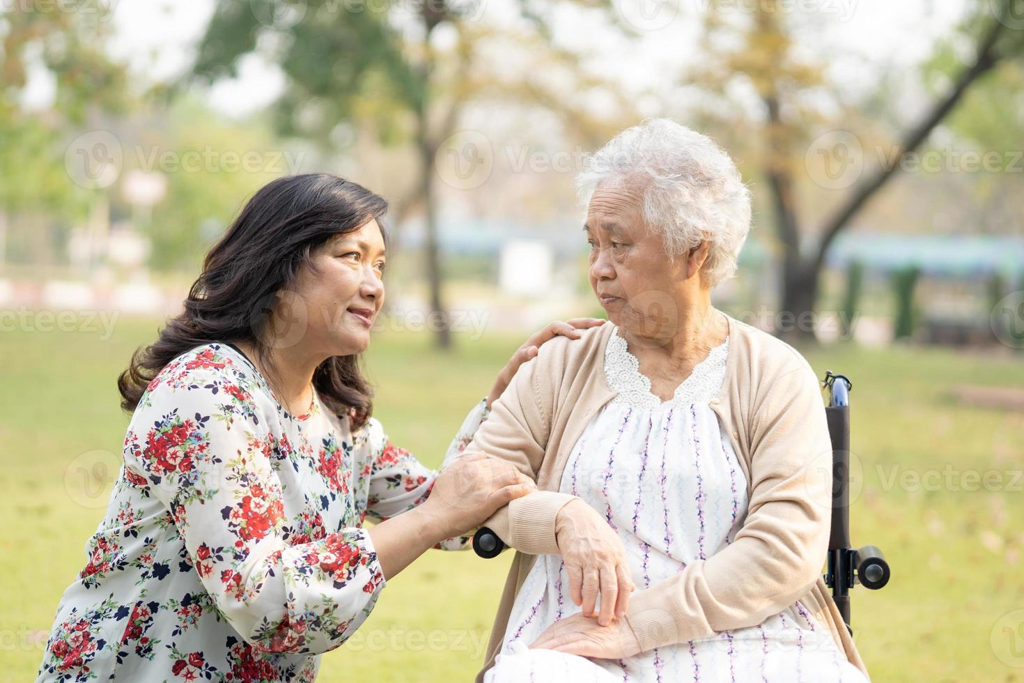 patiente asiatique âgée ou âgée avec soins, aide et soutien sur fauteuil roulant dans le parc en vacances concept médical fort et sain. photo