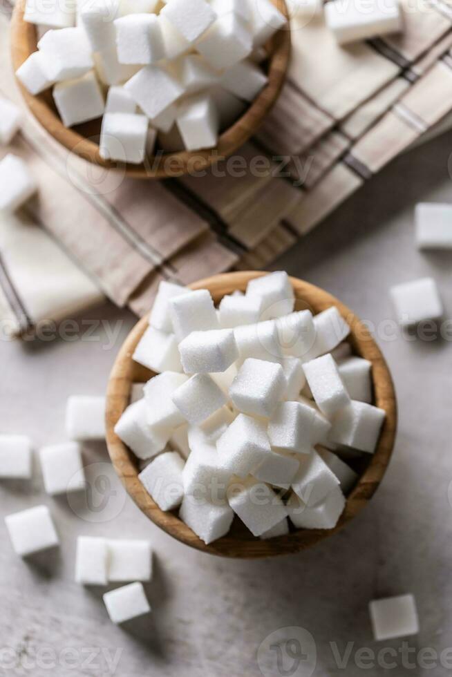 blanc sucre cubes dans une en bois bol sur le table photo