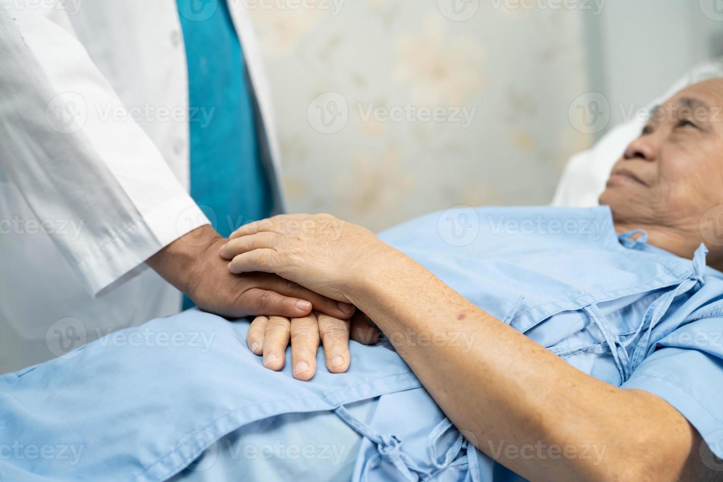 médecin tenant des mains touchantes femme âgée ou vieille dame asiatique patiente avec amour, soins, aide, encouragement et empathie à l'hôpital de soins infirmiers, concept médical fort et sain photo
