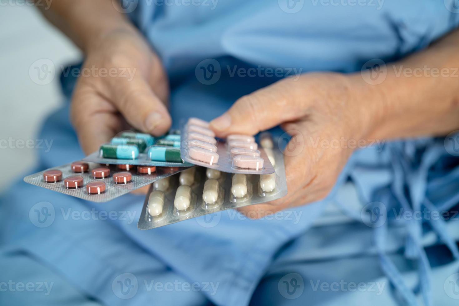 Une patiente asiatique âgée ou âgée tenant des capsules d'antibiotiques dans un emballage blister pour le traitement d'une infection patiente dans le concept de pharmacie de la pharmacie de l'hôpital. photo