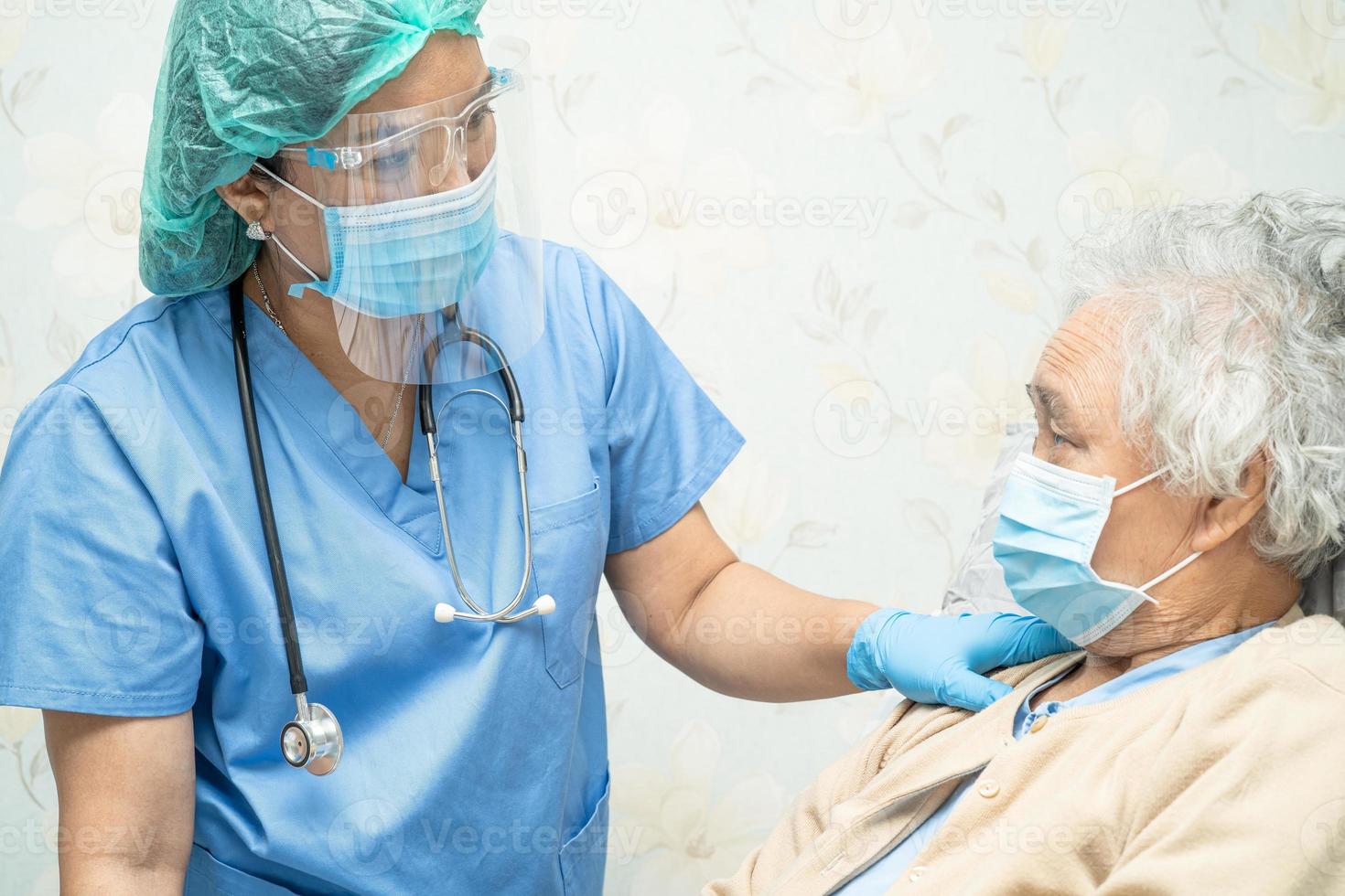 médecin asiatique portant un écran facial et un costume d'EPI pour vérifier que le patient protège l'infection de sécurité épidémie de coronavirus covid-19 dans la salle d'hôpital de quarantaine. photo