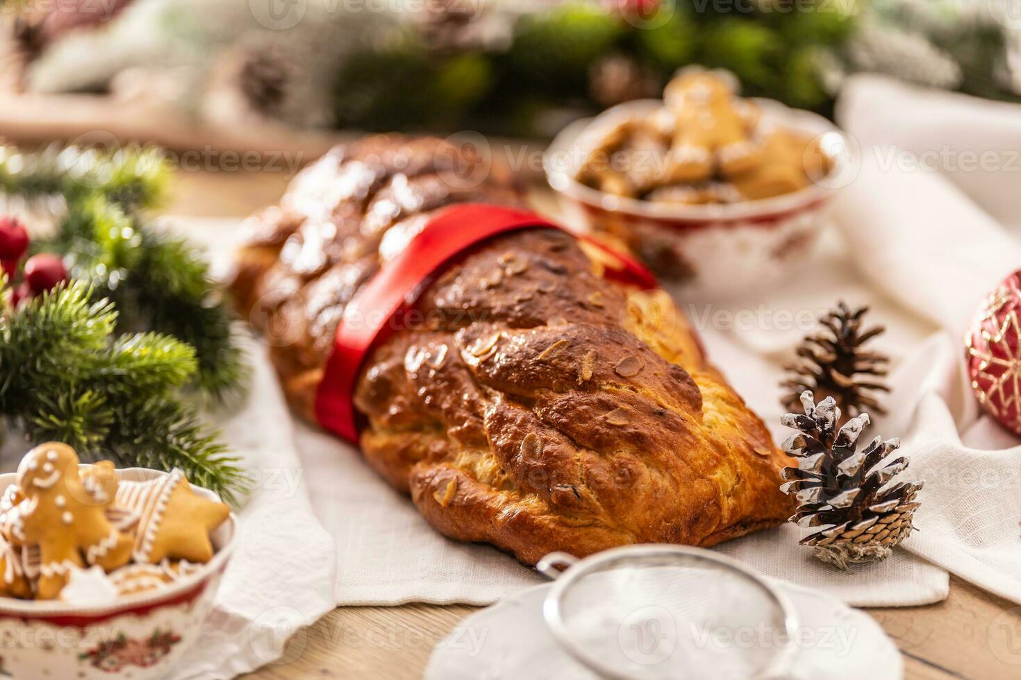 traditionnel tchèque Noël gâteau vanocka sur une de fête table dans de face de une Noël arbre photo