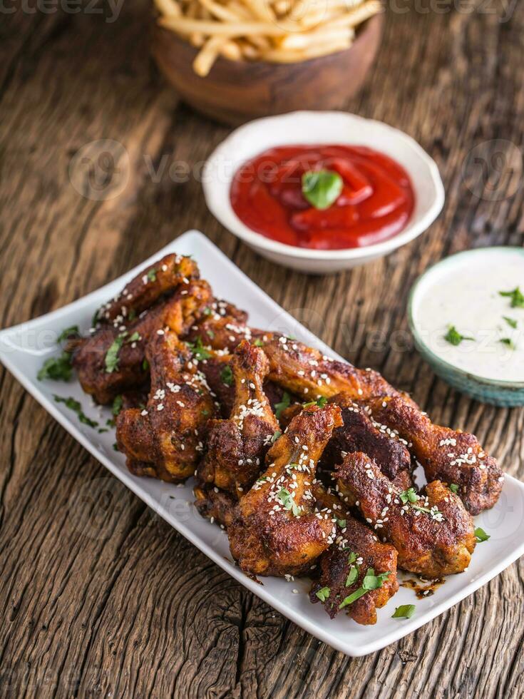 poulet ailes. frit poulet ailes dans blanc bol Ail pansement ketchup et Patate frites. photo