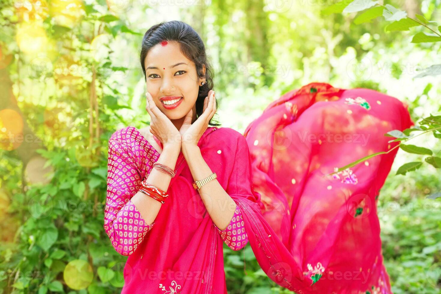 une femme dans une rose sari souriant photo