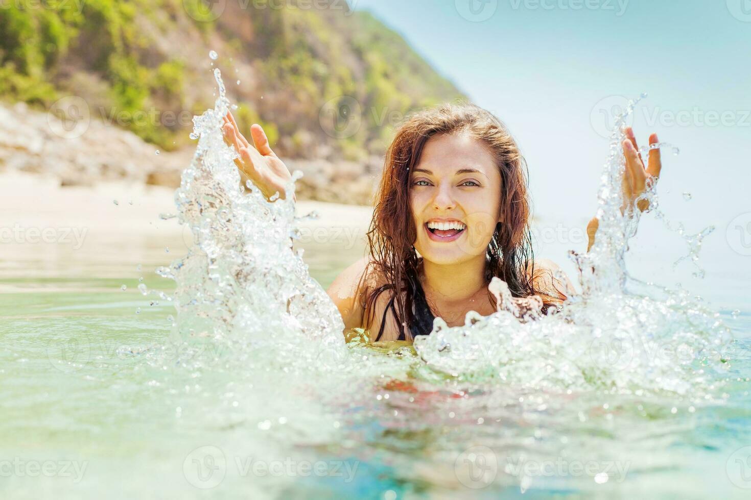 une femme est éclabousser l'eau sur sa visage dans le océan photo