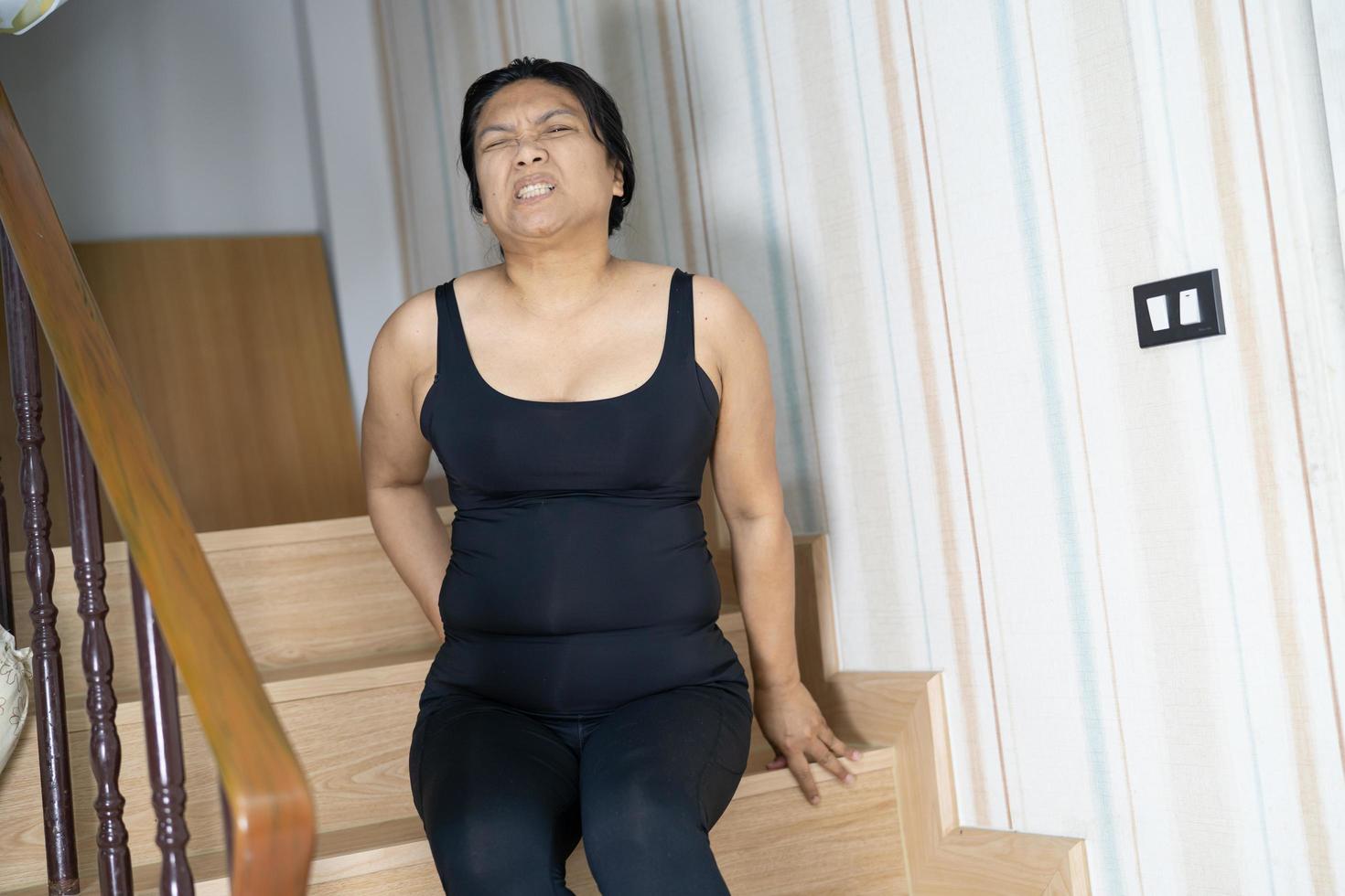 Une patiente asiatique d'âge moyen tombe dans les escaliers à cause de surfaces glissantes photo