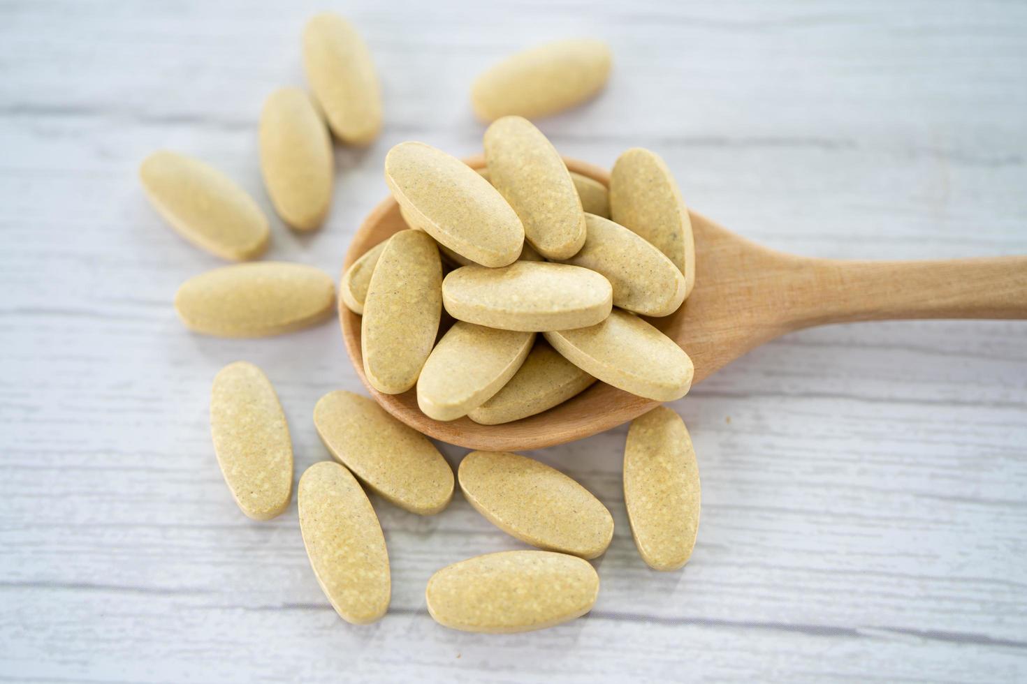 pilules de vitamine c sur cuillère en bois pour une bonne santé. photo