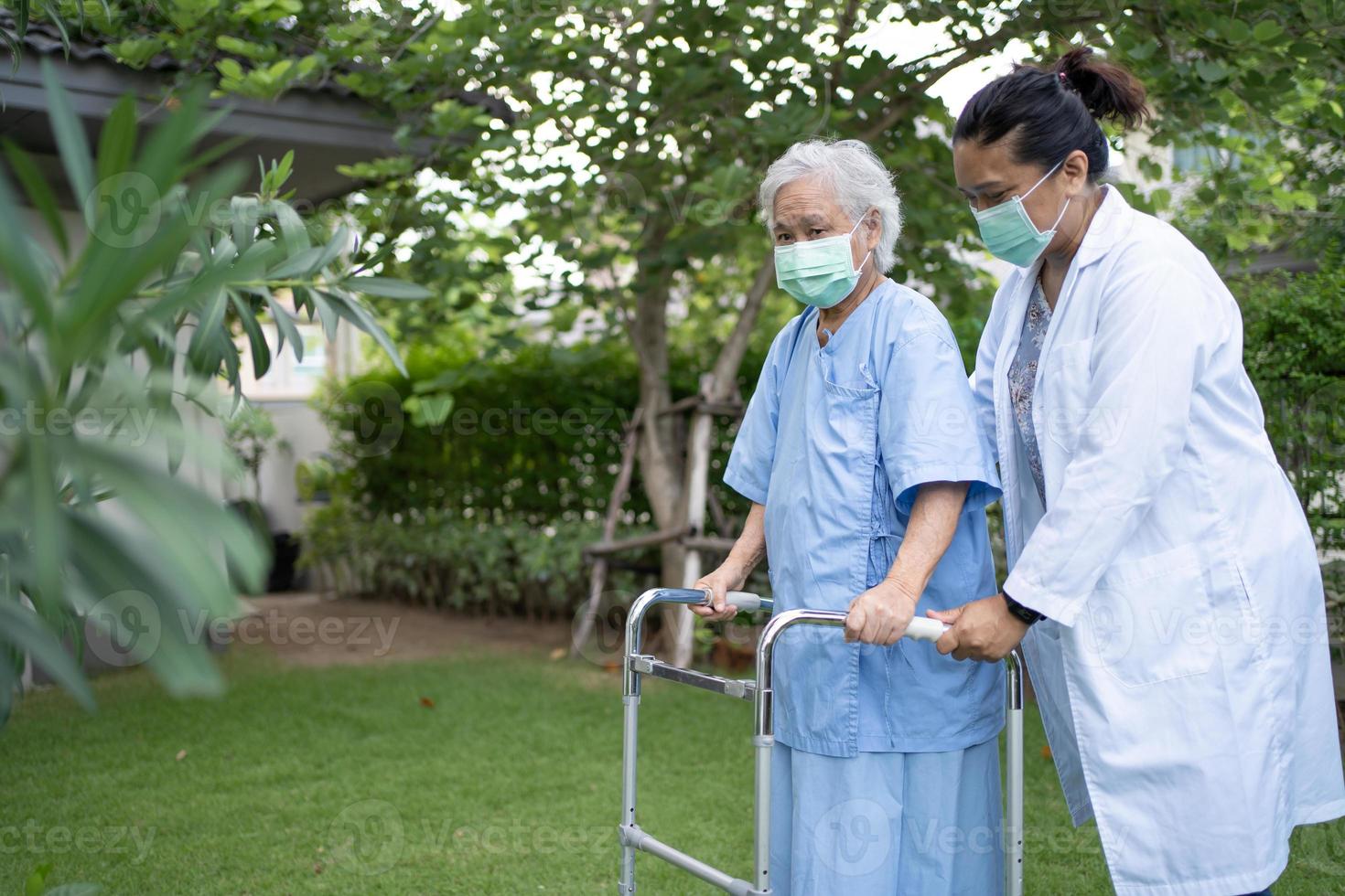 un médecin aide et soigne une vieille dame asiatique âgée ou âgée utilise un marcheur en bonne santé tout en marchant au parc pendant de joyeuses vacances fraîches photo