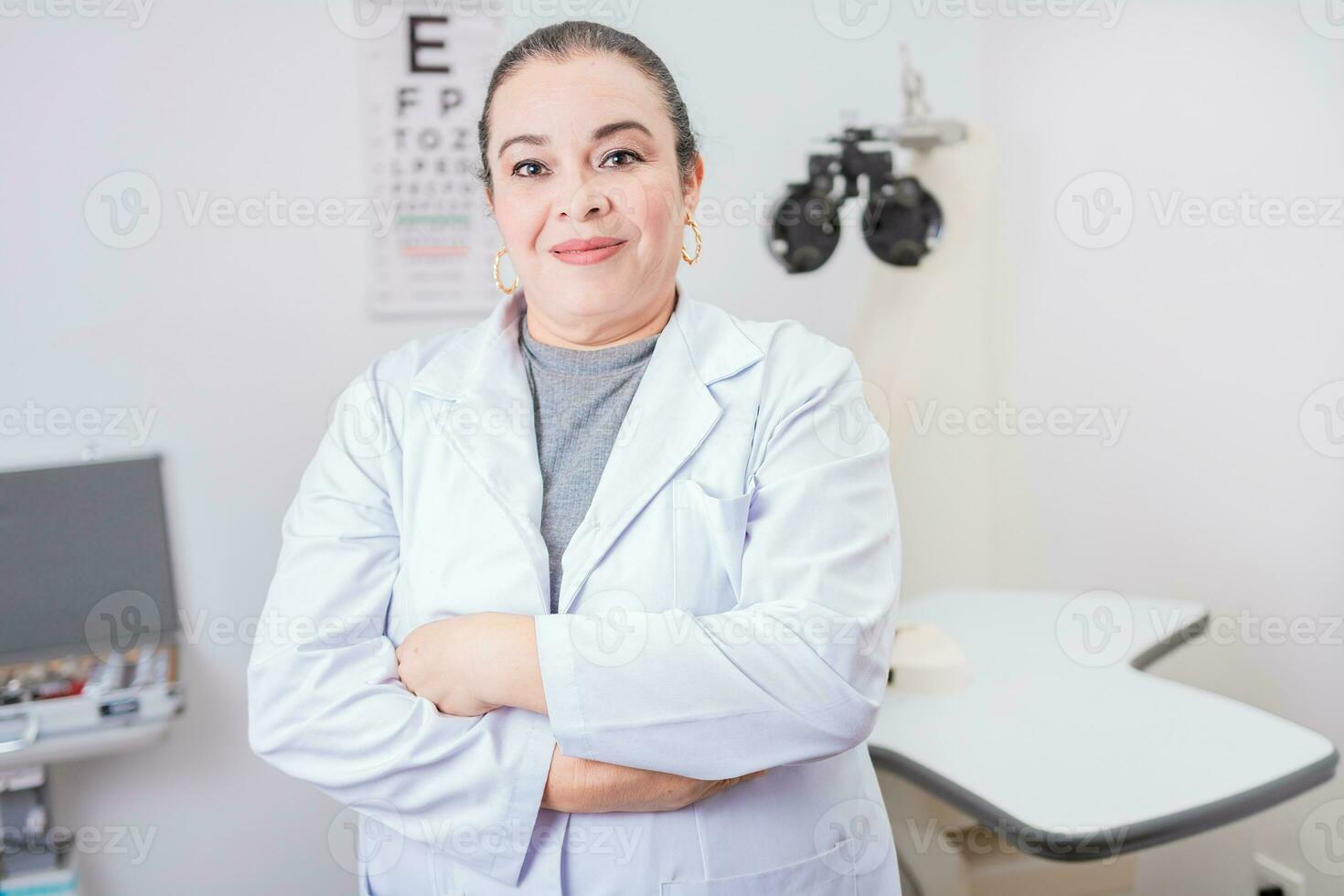 portrait de femelle optométriste avec bras franchi dans le laboratoire. souriant femelle oculiste avec bras franchi dans Bureau photo