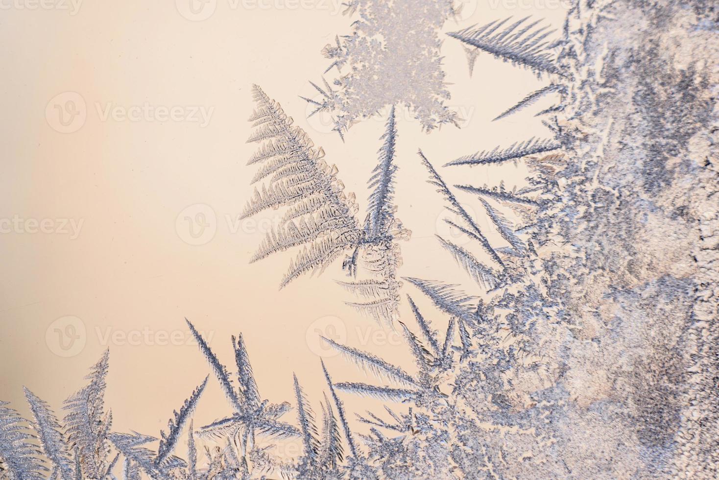 motifs de givre sur la vitre de la fenêtre d'hiver par temps glacial photo
