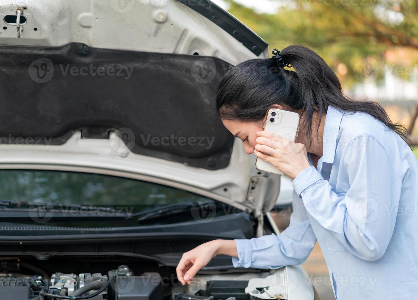 Jeune femme debout près d'une voiture en panne avec un capot qui a des problèmes avec son véhicule photo