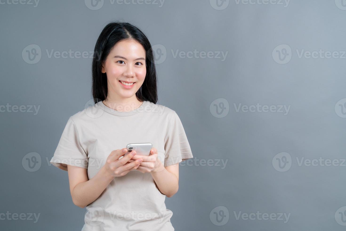 femme asiatique utilisant des applications de téléphonie mobile, appréciant de communiquer à distance en ligne sur un réseau social ou de faire du shopping photo