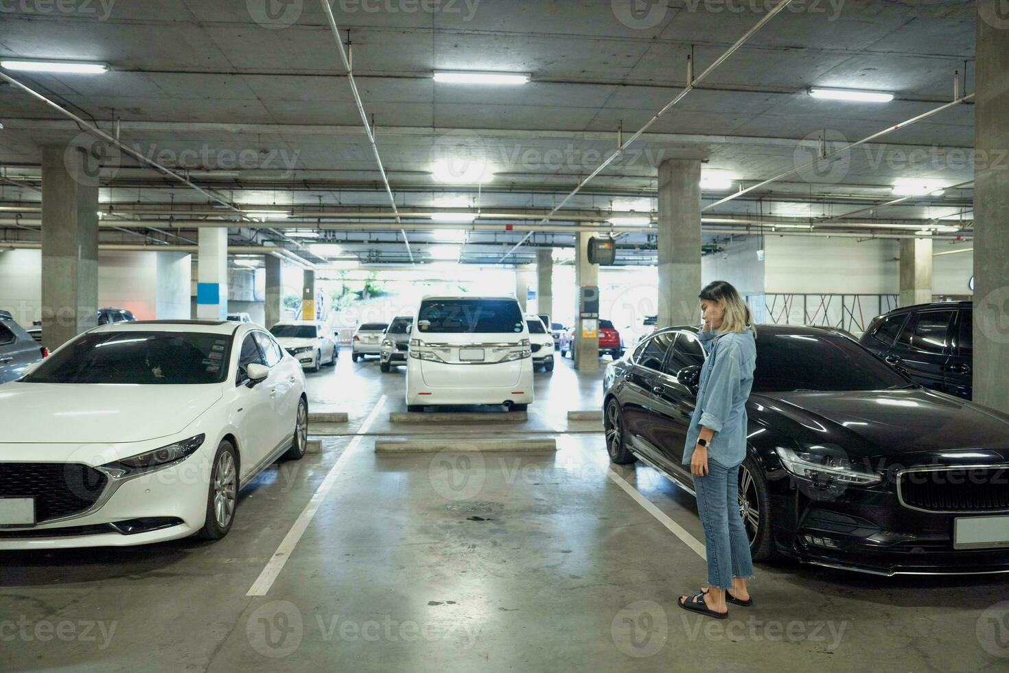asiatique femme voiture volé, ne peut pas trouver voiture à souterrain parking photo