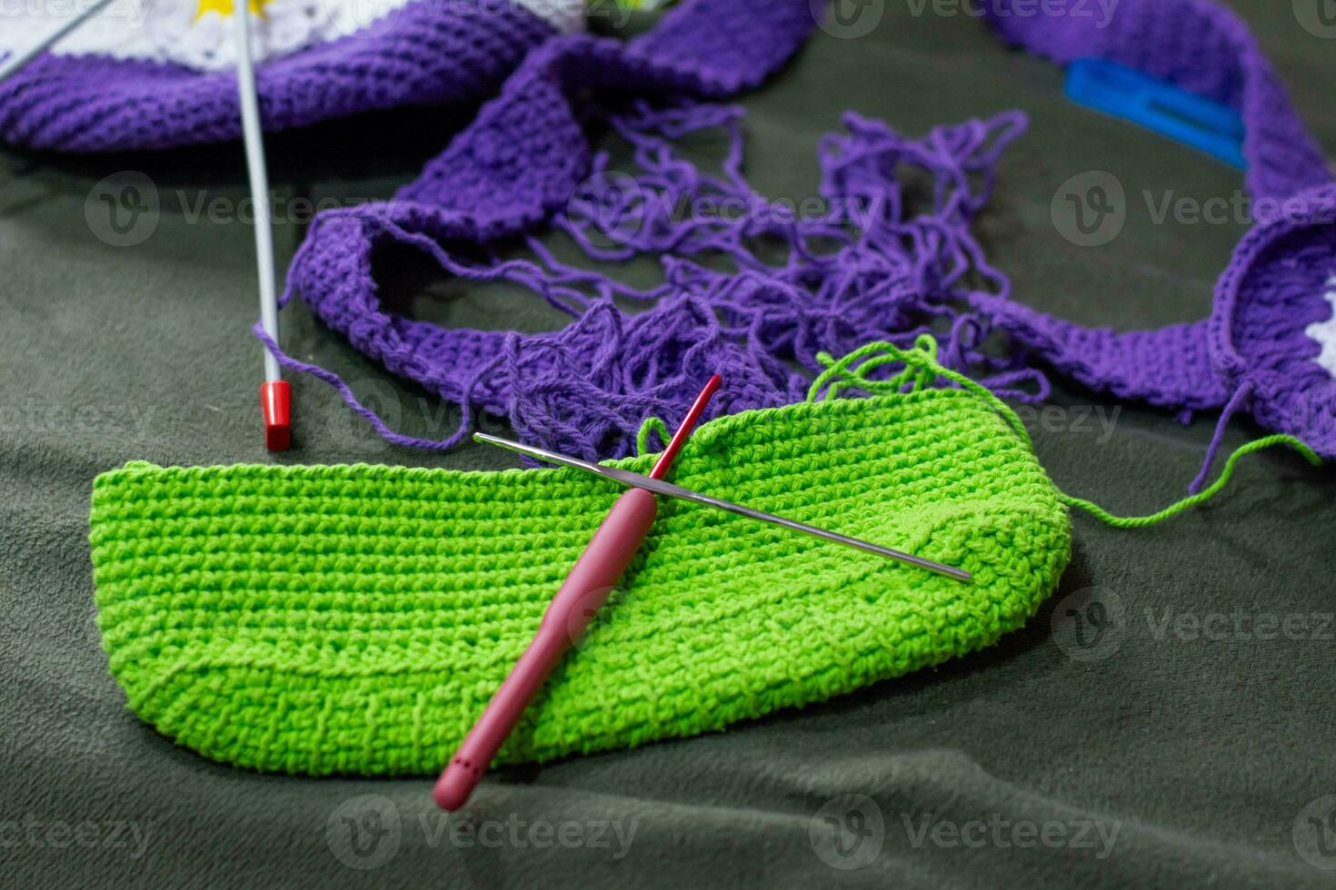 crochet accessoires avec Koche, en utilisant multicolore fils, artisanat, sur vert velours. photo