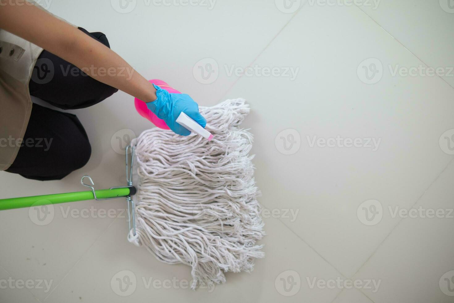 nettoyage Personnel est essuyage tissu avec nettoyeur et désinfectant sur le surface de sol à faire le sol nettoyer avec nettoyage des produits et gratuit de germes accroché à surface de le sol dans vivant chambre. photo