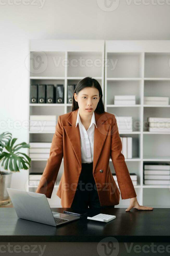 Jeune attrayant asiatique femelle Bureau ouvrier affaires costume souriant à caméra dans moderne Bureau photo