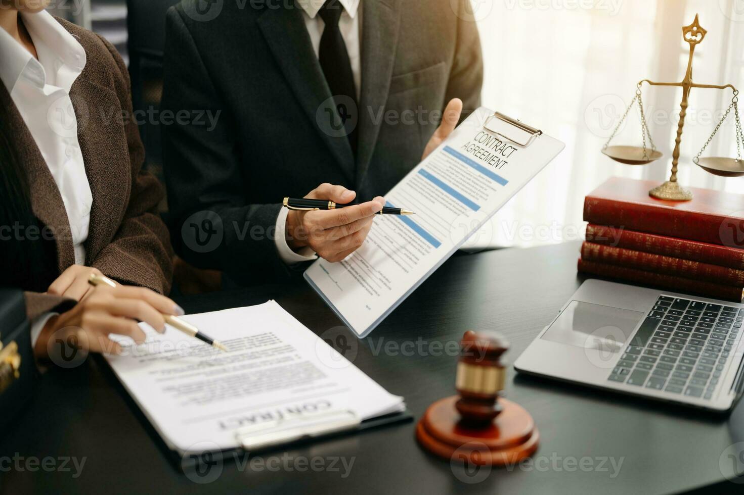 des hommes d'affaires et des avocats discutant des documents contractuels assis à la table. notions de droit, conseils, services juridiques. à la lumière du matin photo