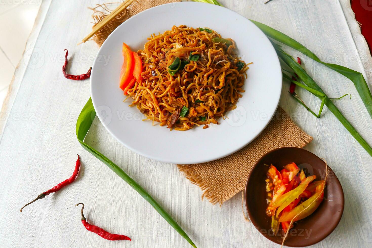 le yakisoba est un sauté traditionnel de nouilles japonaises, à base de nouilles, de chou, de légumes et de viande, assaisonné de sauce aux huîtres ou de sauce yakisoba. yakisoba servi sur assiette photo