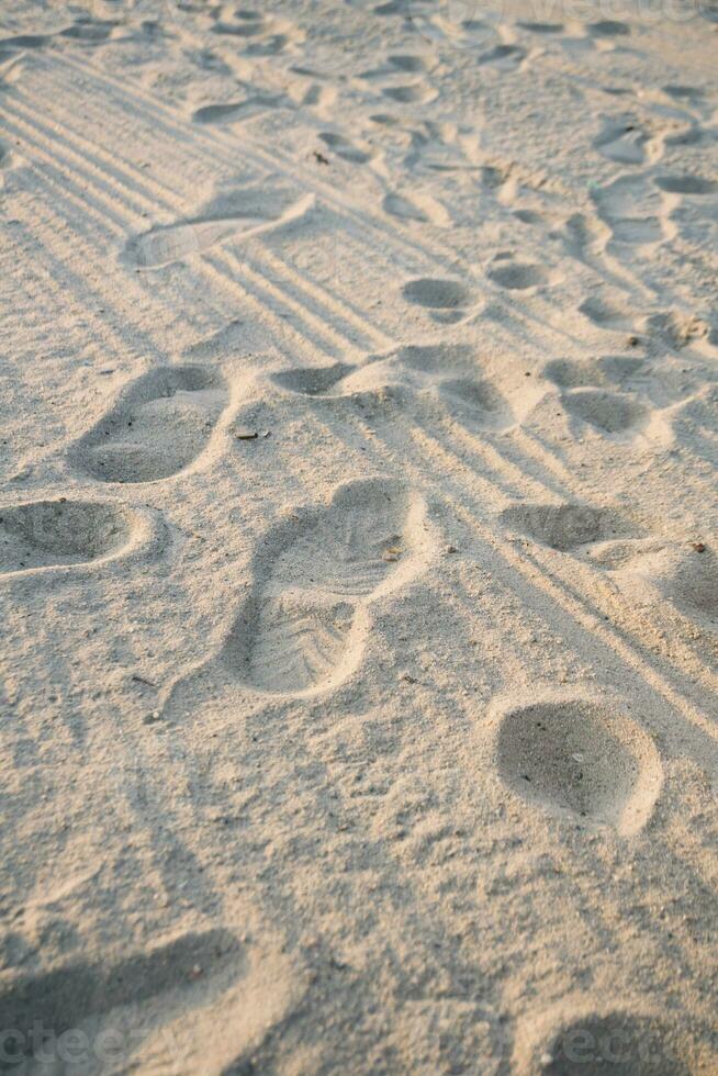 le Contexte de une sablonneux plage avec empreintes de pas. le sable plage Contexte photo