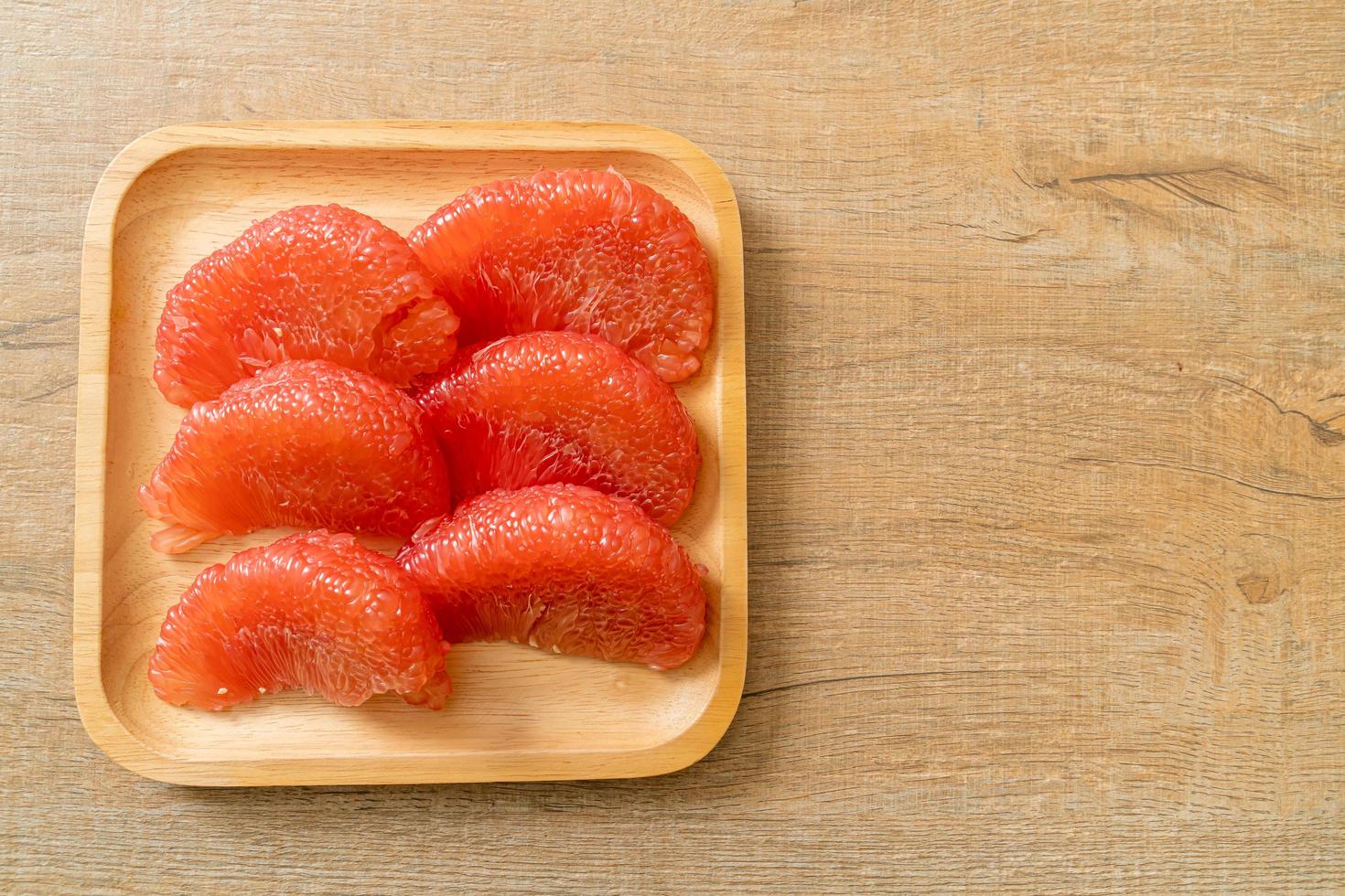 Pomelo rouge frais ou pamplemousse sur assiette photo